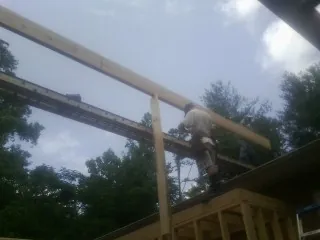 Carpenter setting a ridge beam over a new addition frame — Ice Dam Removal by Roofing Brothers in Ute