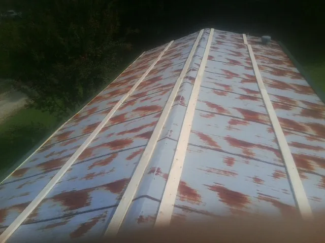 Rusted metal roof panels with new wood purlins before replacement — Storm Damage Roof Repair in Ute by Roofing Brothers