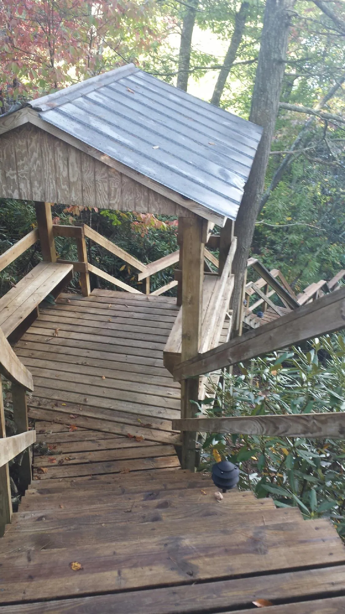 Metal roofed shelter over wooden steps on a wooded walkway — Skylight Repair & Installation work by our crew in Ute
